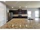 Modern kitchen featuring granite countertops, stainless steel appliances, and dark wood cabinetry at 3522 Fallen Oak Dr, Buford, GA 30519