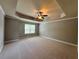 Spacious primary bedroom with neutral walls, carpet, and trey ceiling at 3522 Fallen Oak Dr, Buford, GA 30519