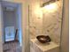 Stylish bathroom vanity with a unique sink, marble countertop and tile accent wall, next to a hallway at 4284 Caroline Ct, Douglasville, GA 30135