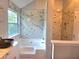 Luxurious bathroom with marble-like tiling, a soaking tub, and separate glass-enclosed shower for a serene, spa-like experience at 4284 Caroline Ct, Douglasville, GA 30135