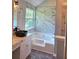Bathroom featuring marble tiled bathtub, modern vanity, and window view at 4284 Caroline Ct, Douglasville, GA 30135