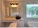 Stylish bathroom boasts marble accent wall, sleek black sink, and bright window, combining luxury with functionality at 4284 Caroline Ct, Douglasville, GA 30135