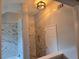 Bathroom featuring marble tiled walk-in shower and modern light fixture at 4284 Caroline Ct, Douglasville, GA 30135
