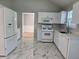 Kitchen features white cabinets, marble-look tile floors, and stainless steel appliances at 4284 Caroline Ct, Douglasville, GA 30135
