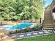 Beautiful in-ground pool and hot tub with lush greenery and stone walkways at 4284 Caroline Ct, Douglasville, GA 30135