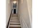 Stairway leading to upper level, features white risers and stringers, and wood treads, topped with modern light fixture at 4284 Caroline Ct, Douglasville, GA 30135