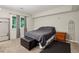 Comfortable bedroom with neutral carpet, complemented by a dark bed, ottoman, and natural light at 6100 Blackwater Trl, Atlanta, GA 30328