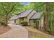 Charming home featuring stone accents, driveway, lush landscaping, and an attached garage nestled amongst mature trees at 6100 Blackwater Trl, Atlanta, GA 30328