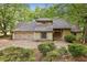Charming home featuring stone accents, lush landscaping, and an attached garage nestled amongst mature trees at 6100 Blackwater Trl, Atlanta, GA 30328