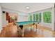 Bright game room with a pool table, hardwood floors, and seamless access to the kitchen at 6100 Blackwater Trl, Atlanta, GA 30328