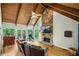 Inviting living room featuring a stone fireplace, wood ceilings, and large windows at 6100 Blackwater Trl, Atlanta, GA 30328