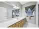 Bright bathroom featuring a long vanity with lots of cabinets, a framed mirror, and decorative window treatments at 8110 Lakemont Close, Mcdonough, GA 30253