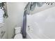 Clean bathroom featuring a white bathtub with shower, a toilet, and a window with curtains at 8110 Lakemont Close, Mcdonough, GA 30253