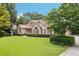 Lovely brick home with a verdant lawn and a beautiful blossoming tree in a sunny outdoor setting at 8110 Lakemont Close, Mcdonough, GA 30253