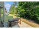 Backyard featuring a patio with a wooden table set, lush greenery, and trees offering privacy at 10137 Cormac St, Jonesboro, GA 30238