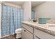 Bathroom featuring double sinks with granite countertops, a large mirror, and a shower with a blue patterned curtain at 10137 Cormac St, Jonesboro, GA 30238