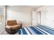 Bedroom featuring a comfortable recliner, neutral walls, and a bed with blue striped bedding at 10137 Cormac St, Jonesboro, GA 30238