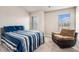 Comfortable bedroom featuring two windows and a cozy brown recliner next to a bed with blue striped bedding at 10137 Cormac St, Jonesboro, GA 30238