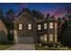 Charming two-story brick home at dusk with manicured lawn and attached garage at 10137 Cormac St, Jonesboro, GA 30238