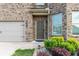 Close-up of a home's front door and garage with well-maintained landscaping at 10137 Cormac St, Jonesboro, GA 30238