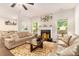 Inviting living room with a cozy fireplace and tan couches on an animal print rug at 10137 Cormac St, Jonesboro, GA 30238