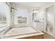 Lovely bright bathroom features a jacuzzi style tub with tile border and double windows at 1850 Thomas Ne Dr, Marietta, GA 30066