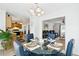 Modern dining area with a glass table and blue upholstered chairs, open to the kitchen and living spaces at 1850 Thomas Ne Dr, Marietta, GA 30066