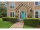 Close up of bright teal front door framed by manicured landscaping and a stone walkway at 1850 Thomas Ne Dr, Marietta, GA 30066