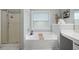 Modern bathroom with a tub, separate shower, and vanity with clean, white accents at 303 Barberry Pl, Canton, GA 30114