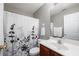 Bright bathroom features a vanity with a white countertop, floral shower curtain and a large mirror at 303 Barberry Pl, Canton, GA 30114