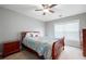 Cozy bedroom with a ceiling fan, large window, and a wooden bed with patterned bedding at 303 Barberry Pl, Canton, GA 30114