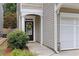 Inviting front door with decorative wreath, framed by a covered porch and lush landscaping at 303 Barberry Pl, Canton, GA 30114