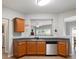 Bright kitchen featuring wood cabinets, stainless steel appliances, and an open view to the living area at 303 Barberry Pl, Canton, GA 30114