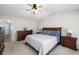 Spacious main bedroom with a ceiling fan, a large bed, dressers, side tables, and carpet at 303 Barberry Pl, Canton, GA 30114