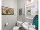 Cozy powder room featuring a pedestal sink, decorative mirror, and neutral wall color at 303 Barberry Pl, Canton, GA 30114