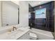 Modern bathroom with navy blue tiles, gold fixtures, marble countertops and a tub/shower combo at 3087 Alston Dr, Decatur, GA 30032