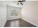 Cozy bedroom with wood-look floors, ceiling fan, and a bright window with tree-patterned wall at 3087 Alston Dr, Decatur, GA 30032