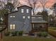 Rear exterior of modern house with a covered porch featuring a grill, a wooden deck and lush landscaping at dusk at 3087 Alston Dr, Decatur, GA 30032