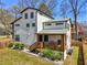 Rear exterior of modern house with a covered porch featuring a grill, a wooden deck and lush landscaping at 3087 Alston Dr, Decatur, GA 30032