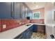 Well-appointed laundry room with blue cabinets, quartz countertops, and stylish tile flooring at 3087 Alston Dr, Decatur, GA 30032
