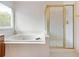 Bright bathroom featuring soaking tub, a glass-enclosed shower, and wood vanity at 3515 Mcclure Woods Dr, Duluth, GA 30096