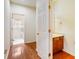 Hallway with hardwood floors leading to laundry room and half bath featuring wood vanity at 3515 Mcclure Woods Dr, Duluth, GA 30096