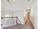 Upstairs hallway with carpet, wood railing, and a pendant light near a large window at 3515 Mcclure Woods Dr, Duluth, GA 30096