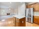 Modern kitchen featuring stainless steel refrigerator, island, hardwood floors, and fireplace at 3515 Mcclure Woods Dr, Duluth, GA 30096