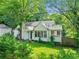 Quaint white brick home featuring a well-maintained lawn and lush greenery at 511 Ashburton Ave, Decatur, GA 30032