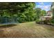 Expansive backyard with a trampoline and stone fireplace creates an outdoor oasis perfect for leisure and entertainment at 1140 Promontory Drive, Marietta, GA 30062
