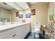 Well-lit bathroom with a white vanity, framed mirror, commode and artistic decor enhancing a serene atmosphere at 1140 Promontory Drive, Marietta, GA 30062
