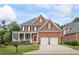 Charming two-story brick home with a covered front porch, two-car garage, and landscaped yard at 1140 Promontory Drive, Marietta, GA 30062