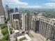 A vibrant cityscape showcasing modern high-rise buildings and lush greenery under a sunny, partly cloudy sky at 1280 W Peachtree Nw St # 2205, Atlanta, GA 30309