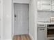 Hallway view of the entryway and kitchen featuring hardwood floors, a gray front door, and modern appliances at 1280 W Peachtree Nw St # 2205, Atlanta, GA 30309